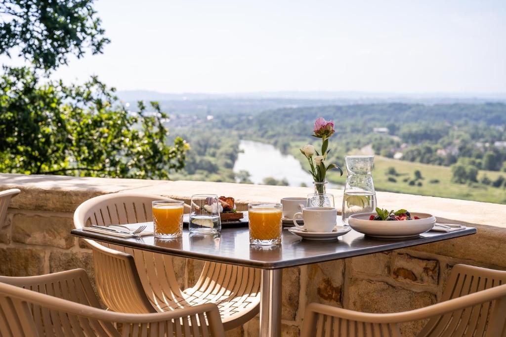 A pyramid stack of empty crystal champagne coupe glasses on a glass table with a dark background and soft lighting.