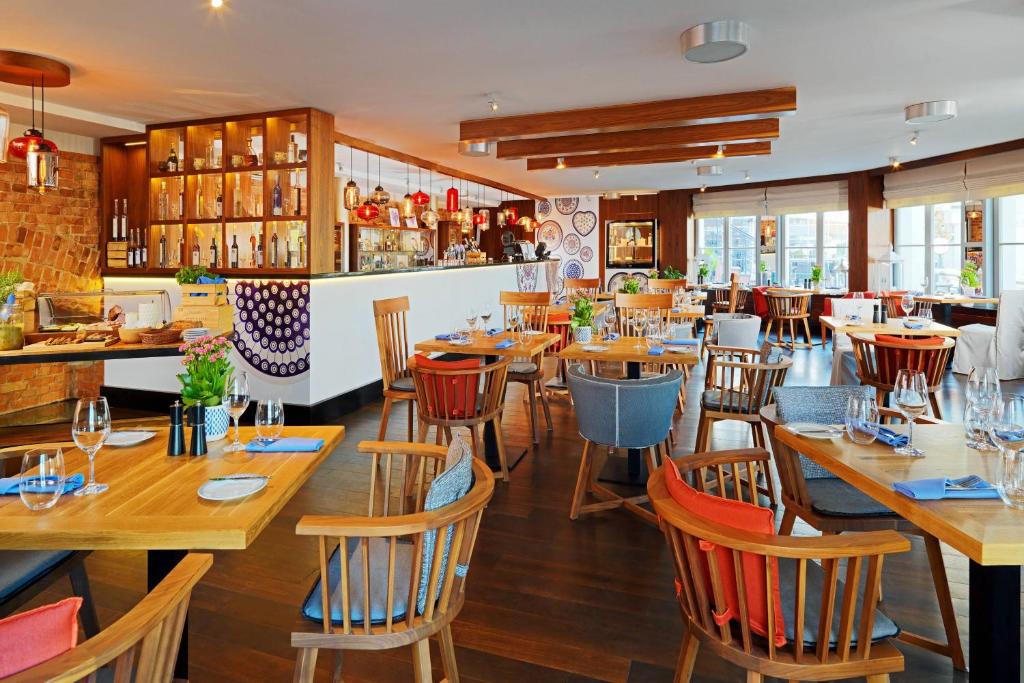 A pyramid stack of empty crystal champagne coupe glasses on a glass table with a dark background and soft lighting.