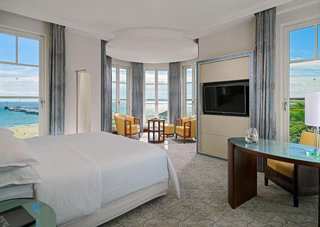 A pyramid stack of empty crystal champagne coupe glasses on a glass table with a dark background and soft lighting.