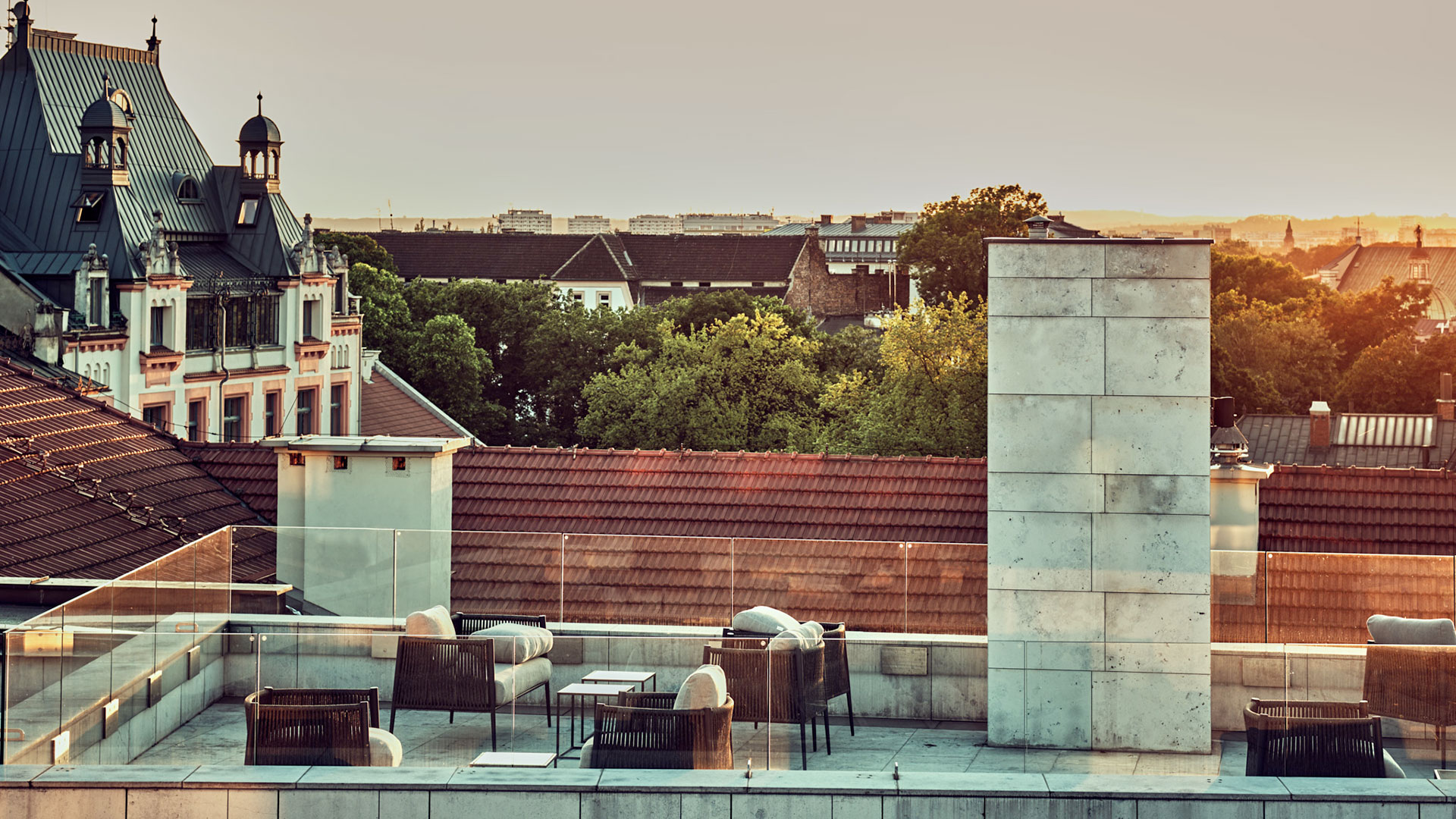 A pyramid stack of empty crystal champagne coupe glasses on a glass table with a dark background and soft lighting.