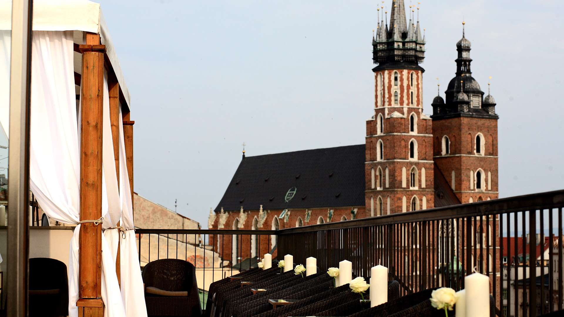 A pyramid stack of empty crystal champagne coupe glasses on a glass table with a dark background and soft lighting.