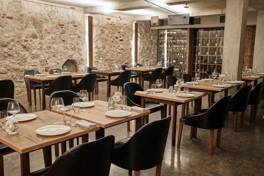 A pyramid stack of empty crystal champagne coupe glasses on a glass table with a dark background and soft lighting.