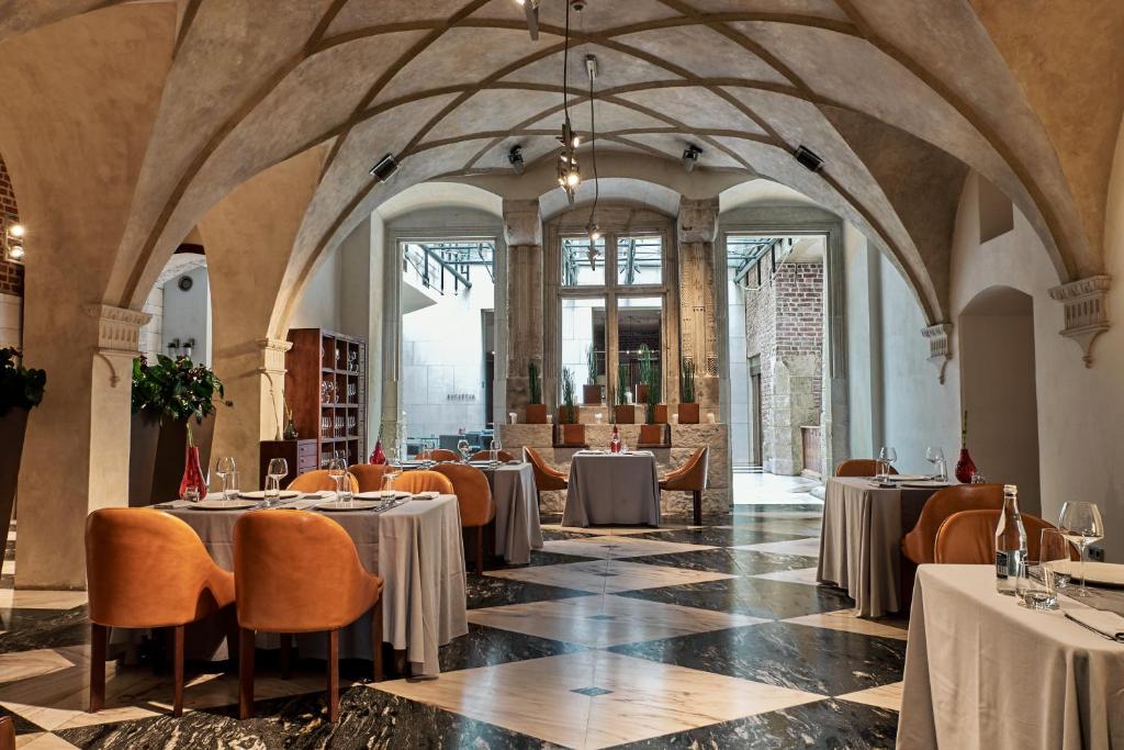 A pyramid stack of empty crystal champagne coupe glasses on a glass table with a dark background and soft lighting.
