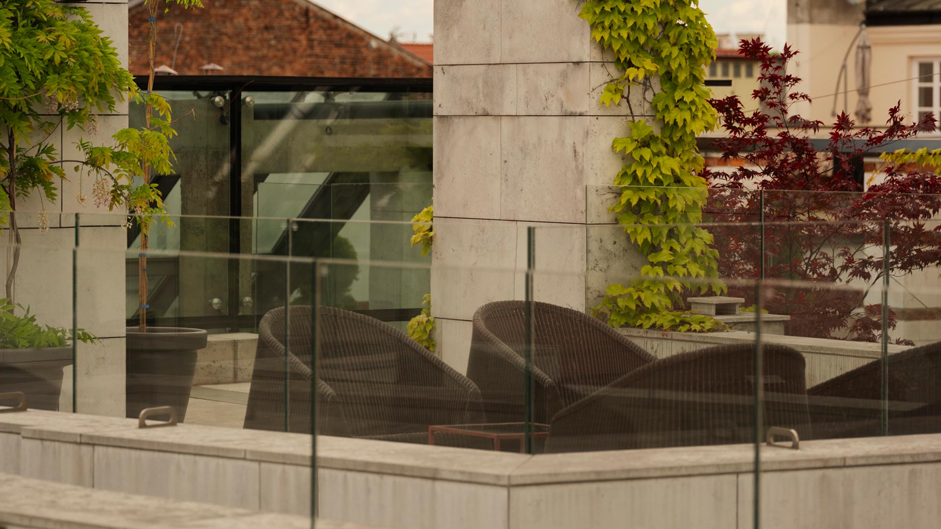 A pyramid stack of empty crystal champagne coupe glasses on a glass table with a dark background and soft lighting.