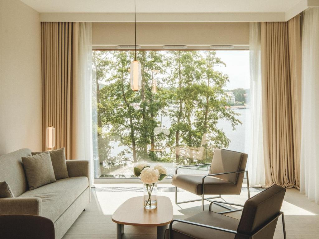 A pyramid stack of empty crystal champagne coupe glasses on a glass table with a dark background and soft lighting.
