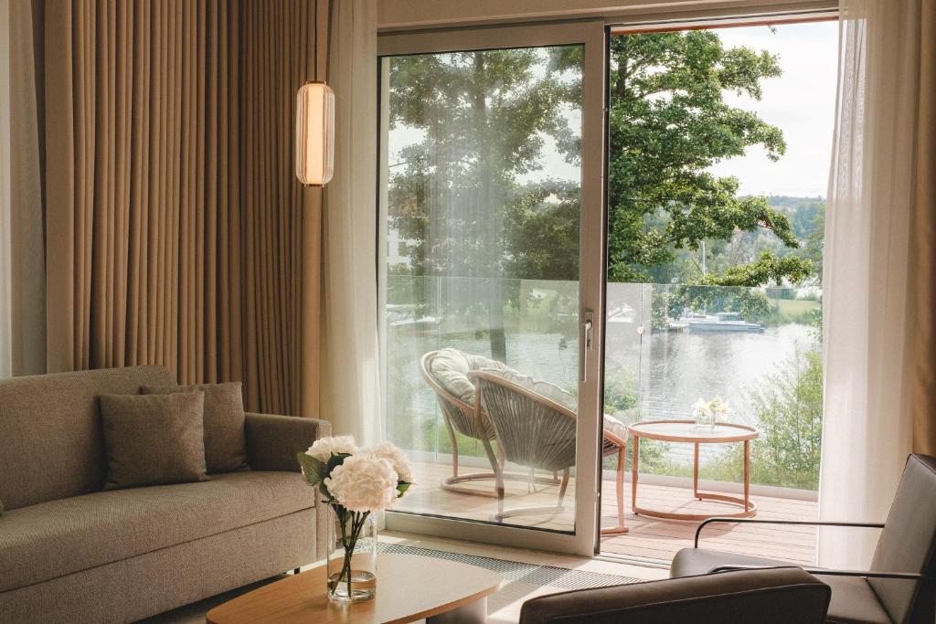 A pyramid stack of empty crystal champagne coupe glasses on a glass table with a dark background and soft lighting.