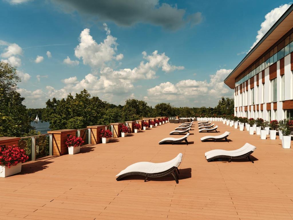 A pyramid stack of empty crystal champagne coupe glasses on a glass table with a dark background and soft lighting.