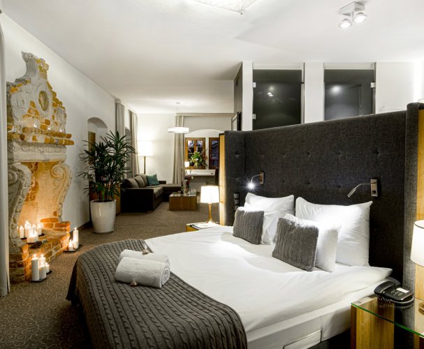 A pyramid stack of empty crystal champagne coupe glasses on a glass table with a dark background and soft lighting.