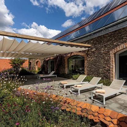 A pyramid stack of empty crystal champagne coupe glasses on a glass table with a dark background and soft lighting.