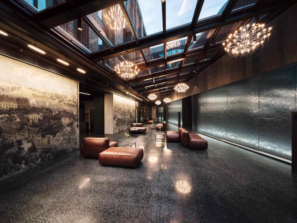 A pyramid stack of empty crystal champagne coupe glasses on a glass table with a dark background and soft lighting.