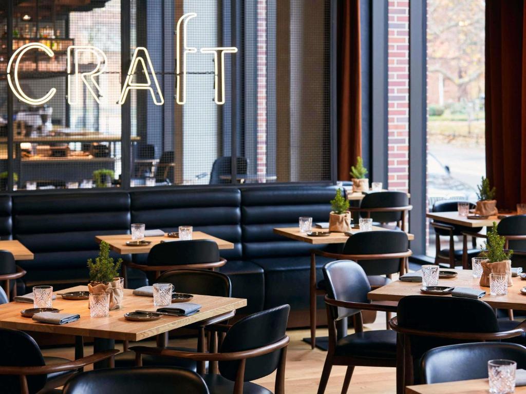 A pyramid stack of empty crystal champagne coupe glasses on a glass table with a dark background and soft lighting.