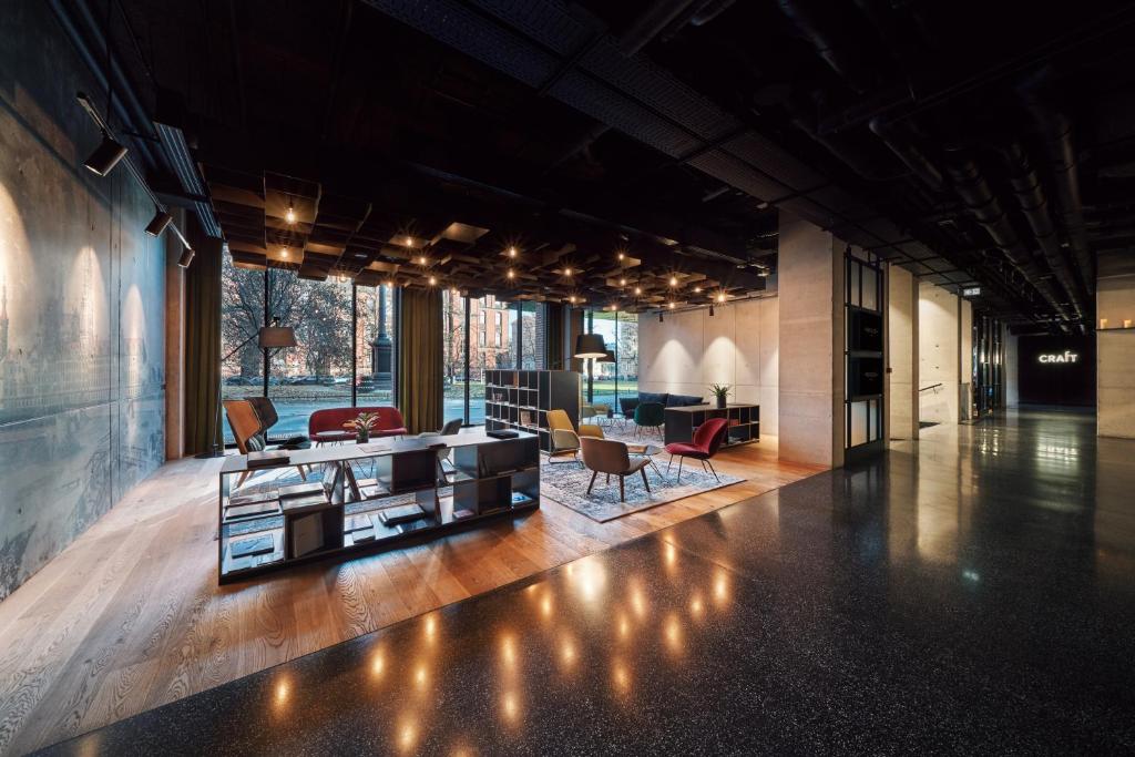 A pyramid stack of empty crystal champagne coupe glasses on a glass table with a dark background and soft lighting.
