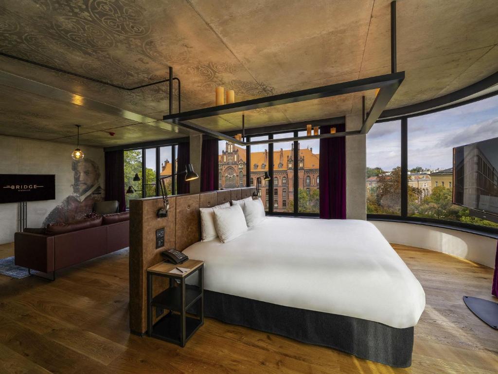 A pyramid stack of empty crystal champagne coupe glasses on a glass table with a dark background and soft lighting.