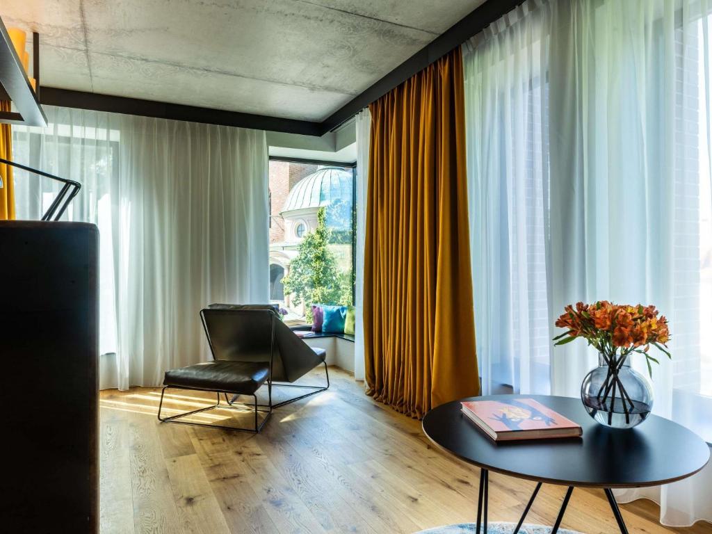 A pyramid stack of empty crystal champagne coupe glasses on a glass table with a dark background and soft lighting.