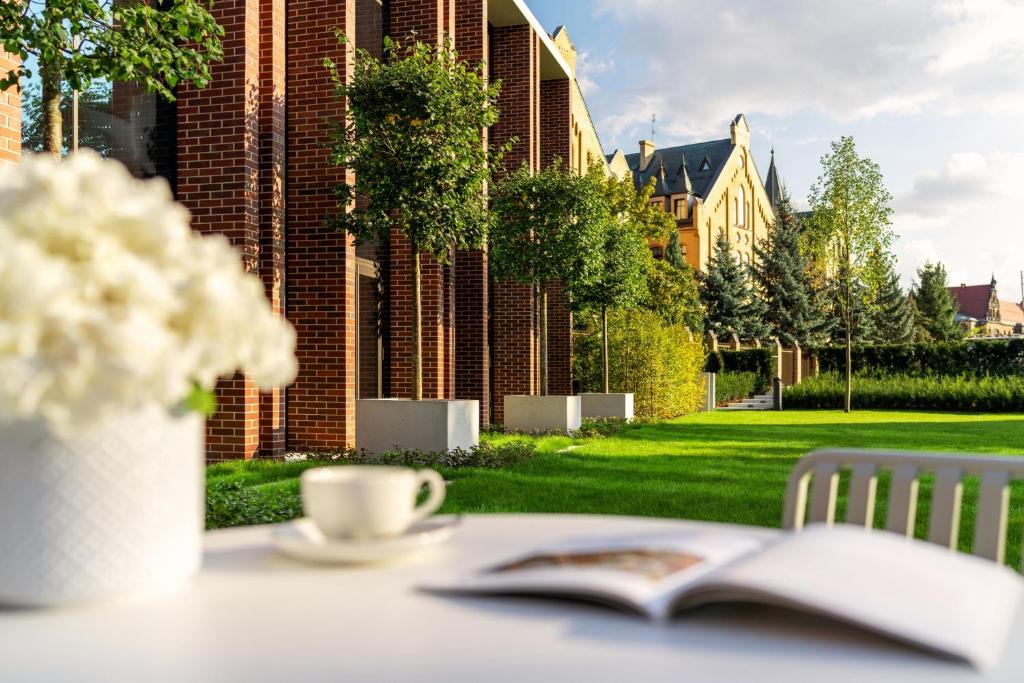 A pyramid stack of empty crystal champagne coupe glasses on a glass table with a dark background and soft lighting.