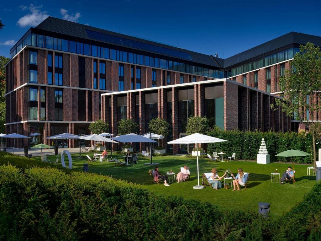A pyramid stack of empty crystal champagne coupe glasses on a glass table with a dark background and soft lighting.