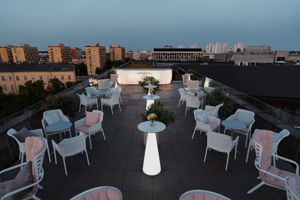 A pyramid stack of empty crystal champagne coupe glasses on a glass table with a dark background and soft lighting.