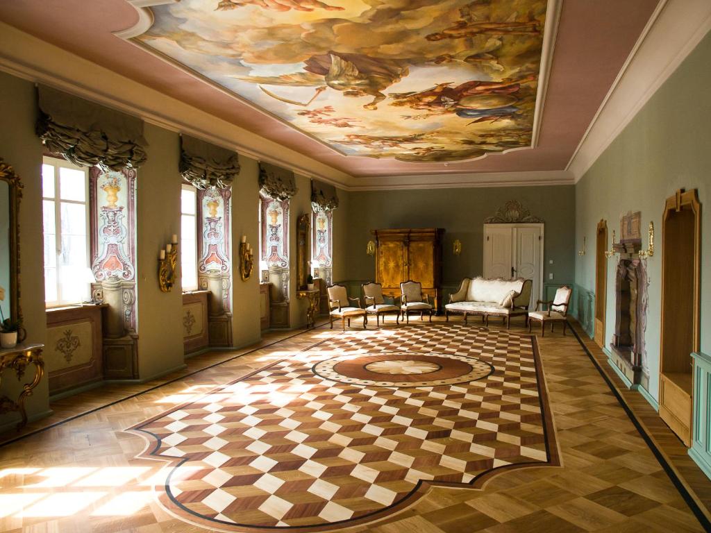 A pyramid stack of empty crystal champagne coupe glasses on a glass table with a dark background and soft lighting.