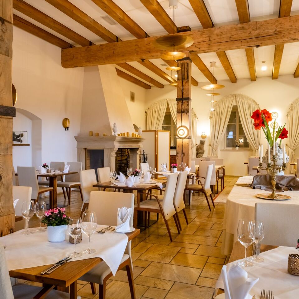 A pyramid stack of empty crystal champagne coupe glasses on a glass table with a dark background and soft lighting.
