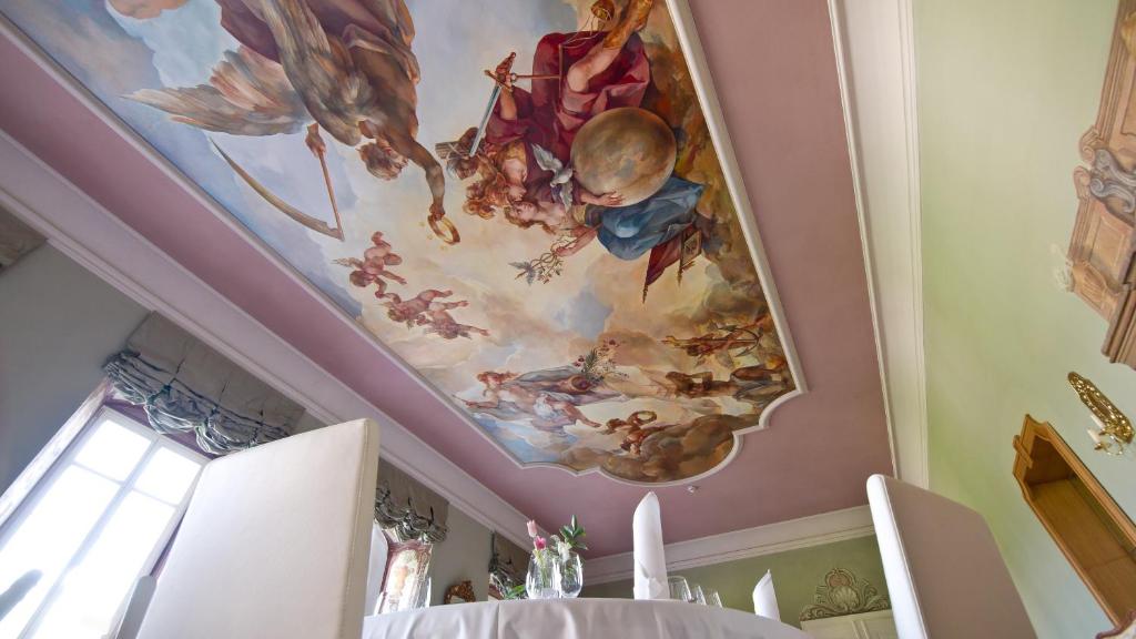 A pyramid stack of empty crystal champagne coupe glasses on a glass table with a dark background and soft lighting.