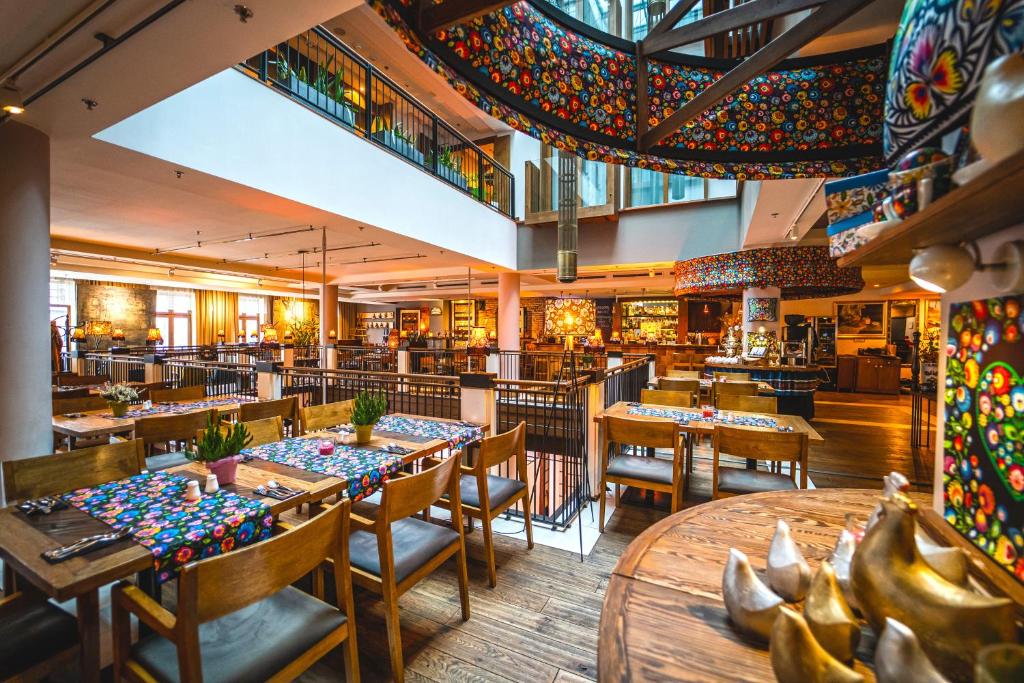 A pyramid stack of empty crystal champagne coupe glasses on a glass table with a dark background and soft lighting.