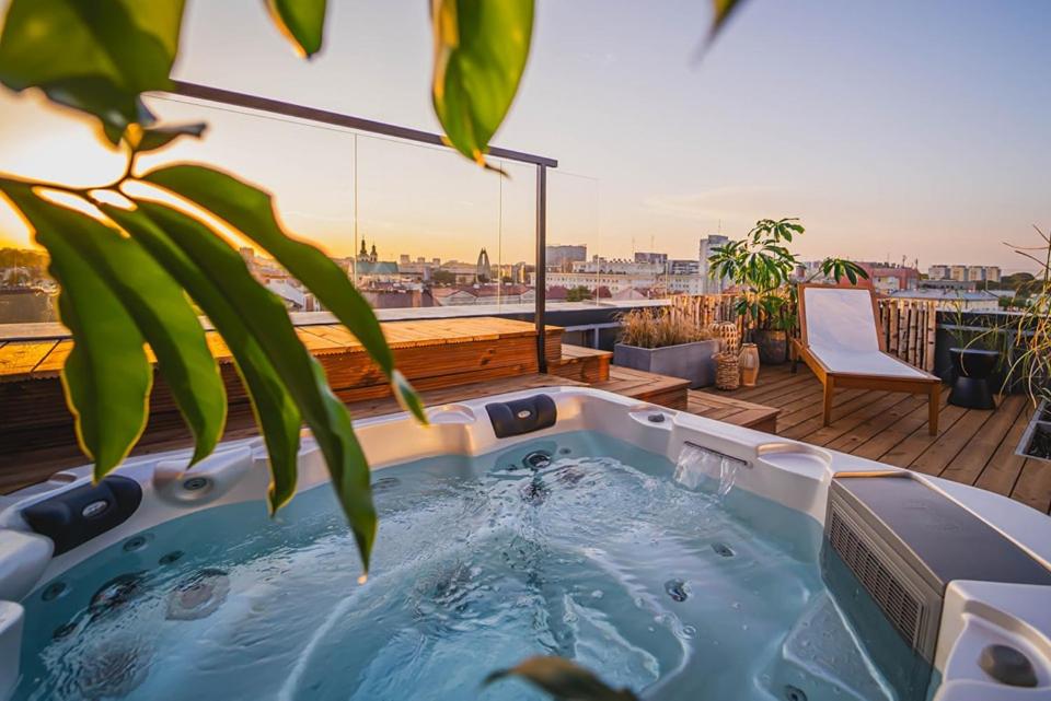 A pyramid stack of empty crystal champagne coupe glasses on a glass table with a dark background and soft lighting.
