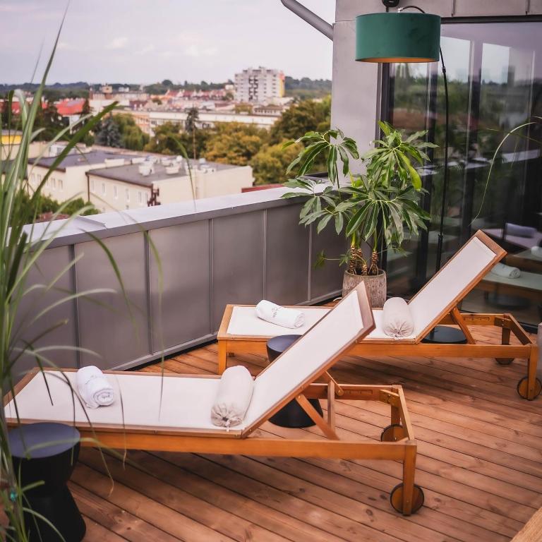 A pyramid stack of empty crystal champagne coupe glasses on a glass table with a dark background and soft lighting.