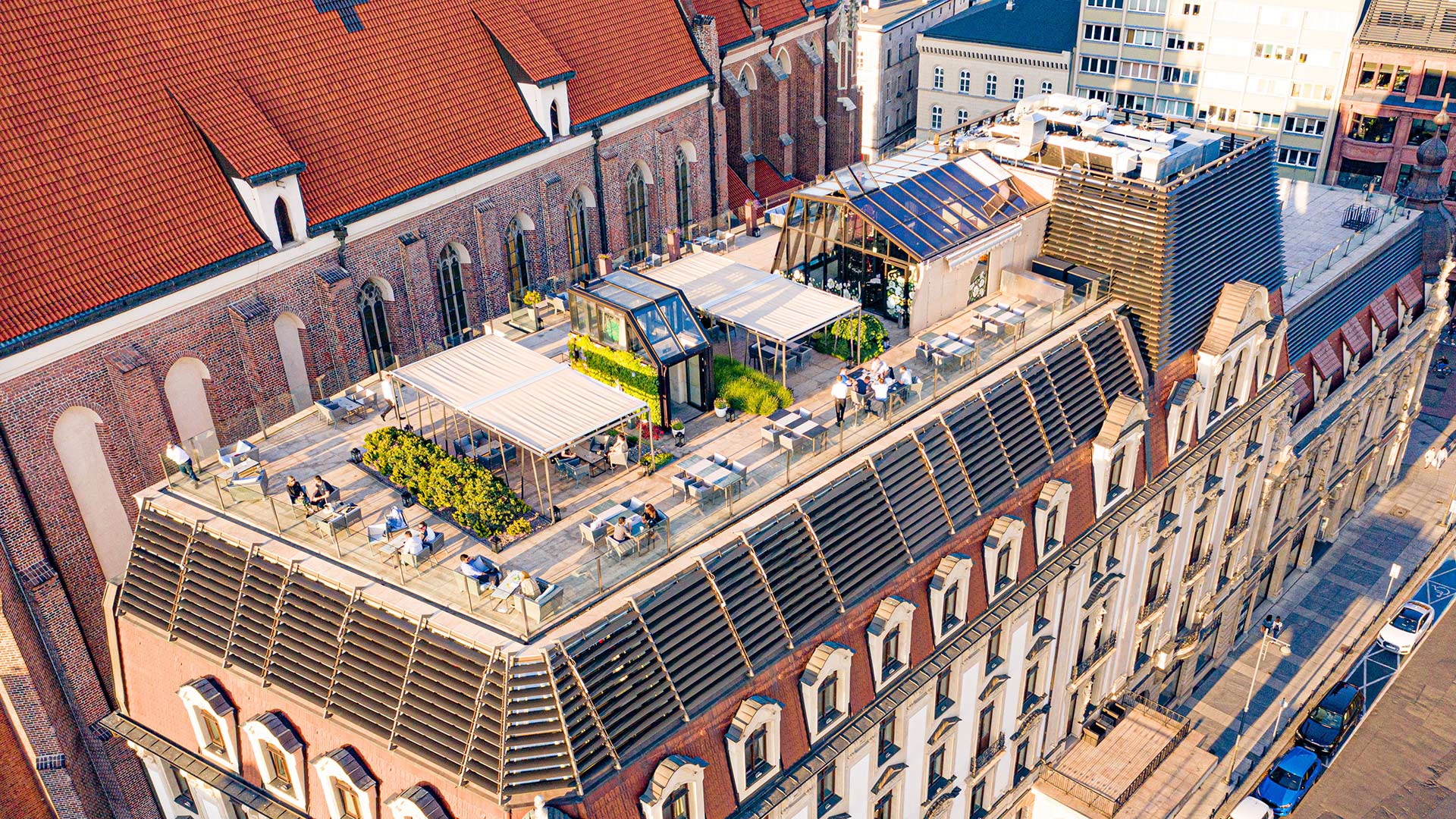 A pyramid stack of empty crystal champagne coupe glasses on a glass table with a dark background and soft lighting.