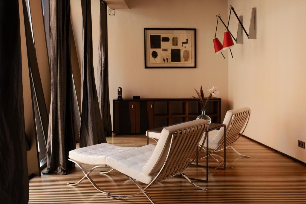 A pyramid stack of empty crystal champagne coupe glasses on a glass table with a dark background and soft lighting.
