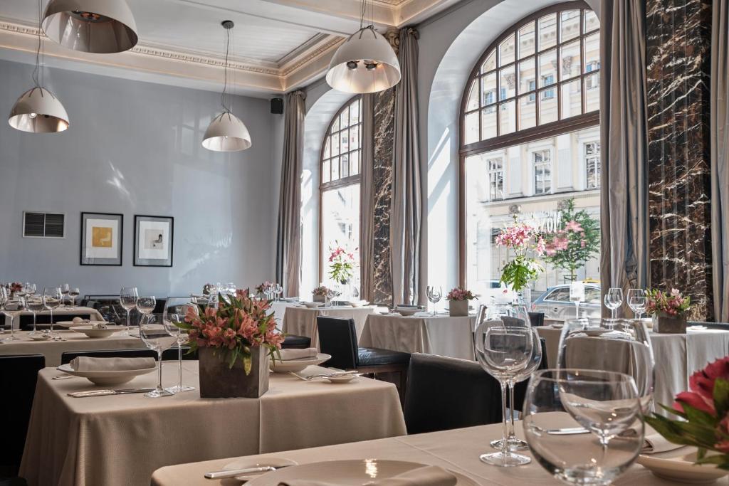 A pyramid stack of empty crystal champagne coupe glasses on a glass table with a dark background and soft lighting.