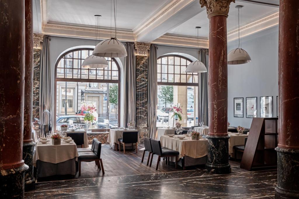 A pyramid stack of empty crystal champagne coupe glasses on a glass table with a dark background and soft lighting.