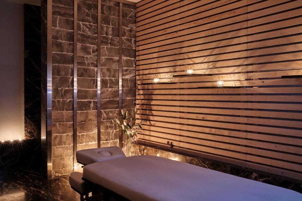 A pyramid stack of empty crystal champagne coupe glasses on a glass table with a dark background and soft lighting.