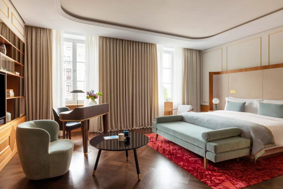 A pyramid stack of empty crystal champagne coupe glasses on a glass table with a dark background and soft lighting.