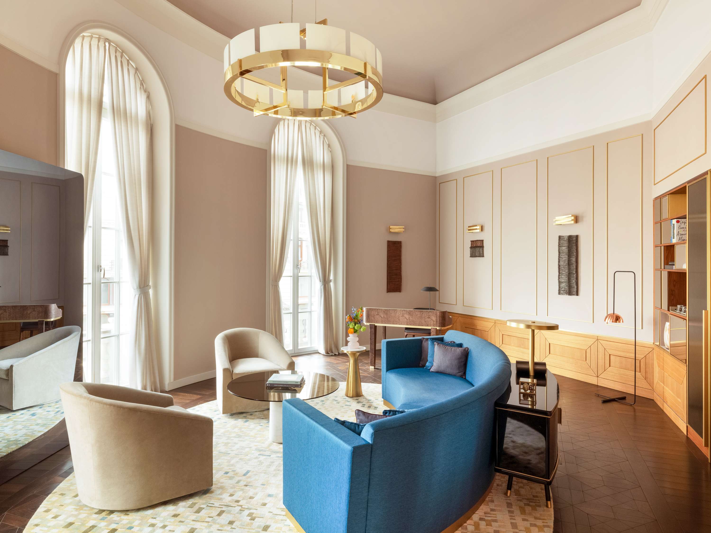 A pyramid stack of empty crystal champagne coupe glasses on a glass table with a dark background and soft lighting.