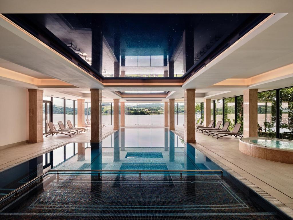 A pyramid stack of empty crystal champagne coupe glasses on a glass table with a dark background and soft lighting.