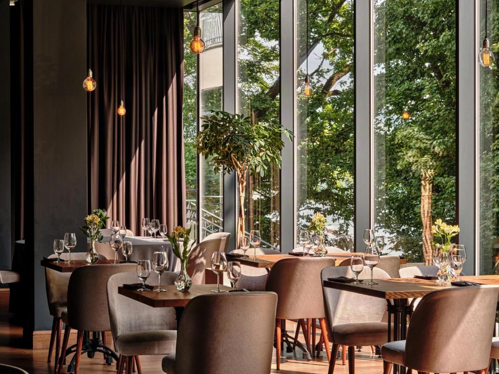 A pyramid stack of empty crystal champagne coupe glasses on a glass table with a dark background and soft lighting.