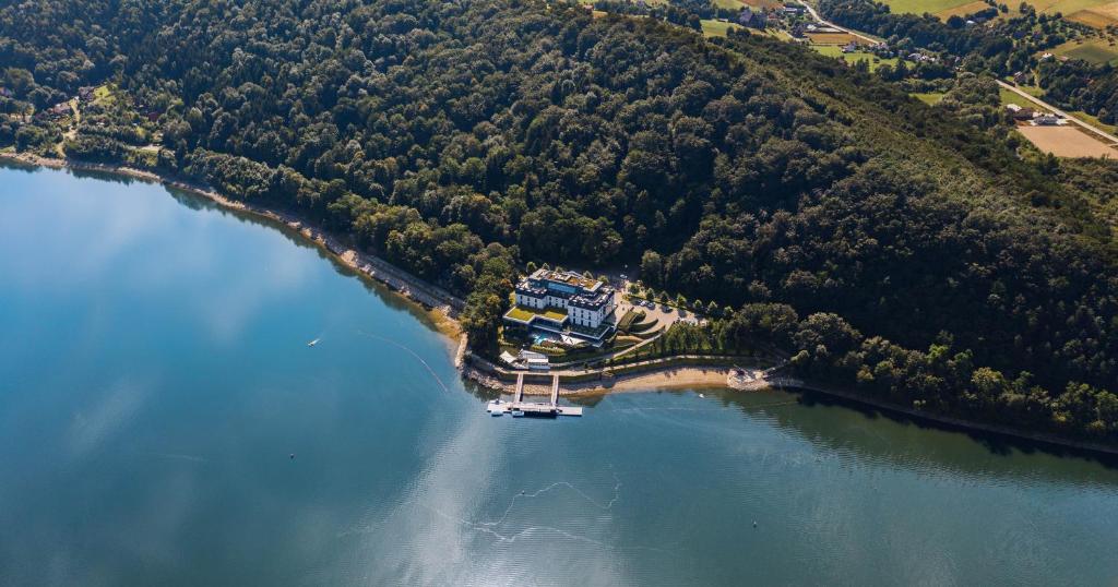 A pyramid stack of empty crystal champagne coupe glasses on a glass table with a dark background and soft lighting.