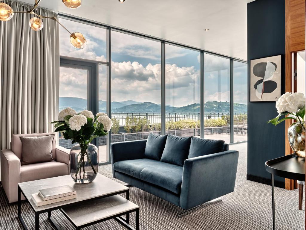 A pyramid stack of empty crystal champagne coupe glasses on a glass table with a dark background and soft lighting.