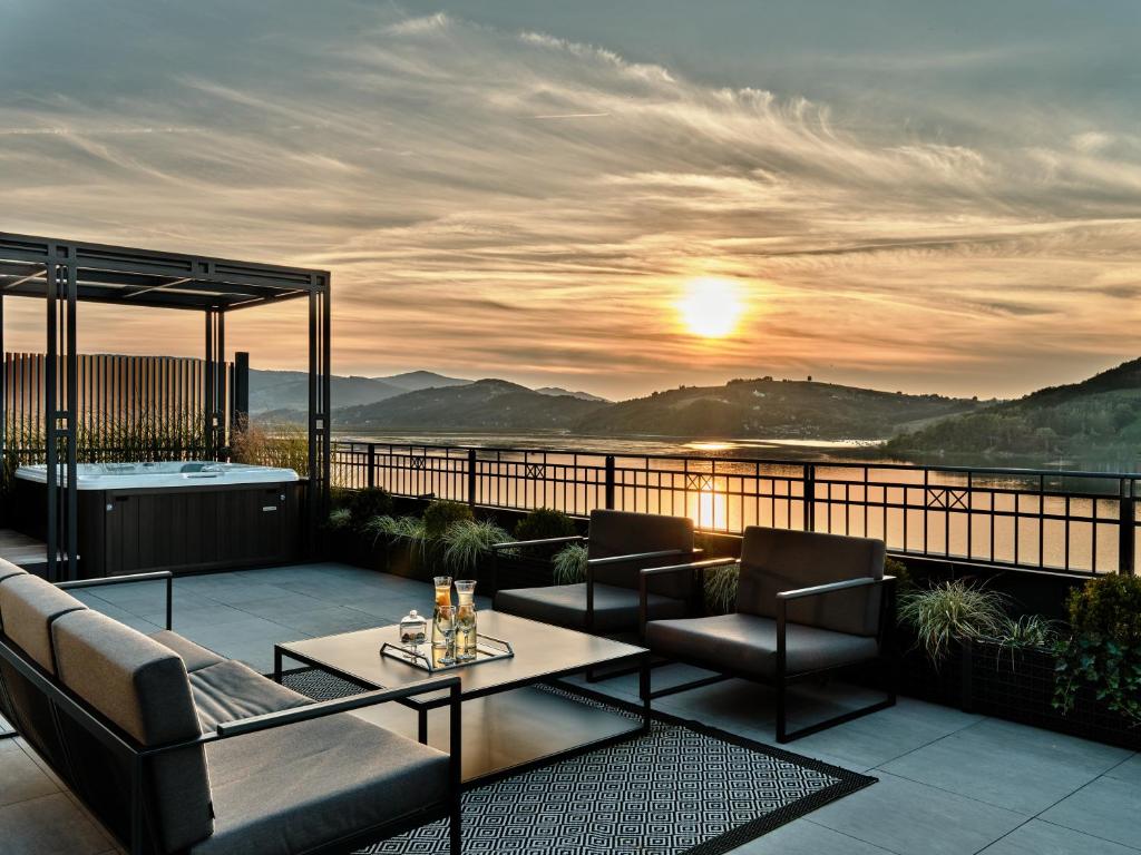 A pyramid stack of empty crystal champagne coupe glasses on a glass table with a dark background and soft lighting.