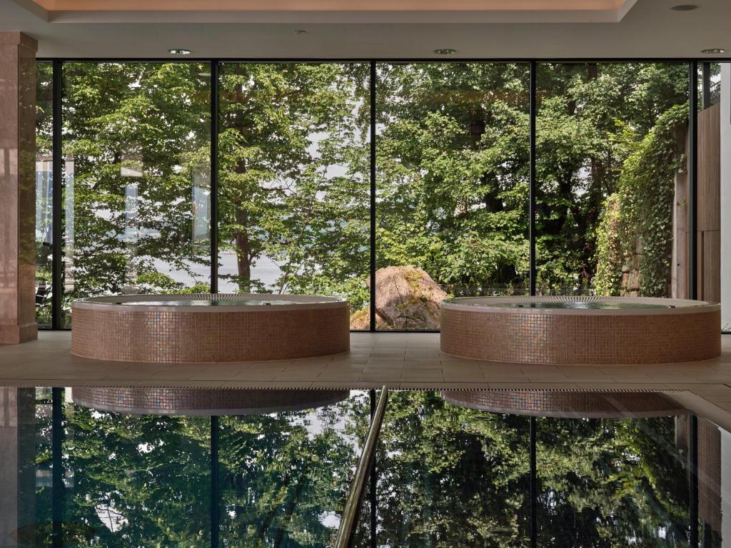 A pyramid stack of empty crystal champagne coupe glasses on a glass table with a dark background and soft lighting.
