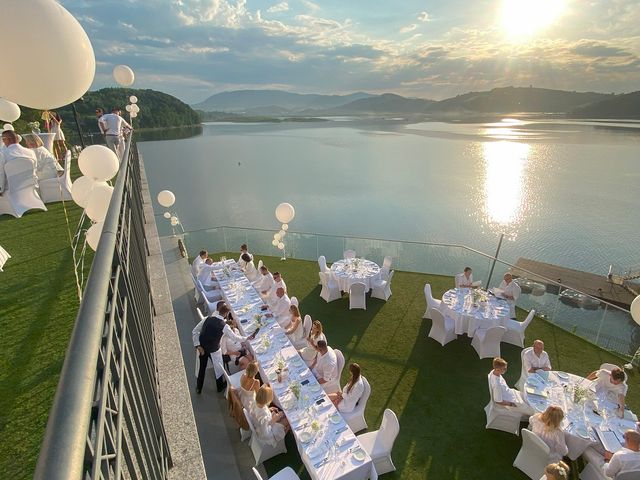 A pyramid stack of empty crystal champagne coupe glasses on a glass table with a dark background and soft lighting.