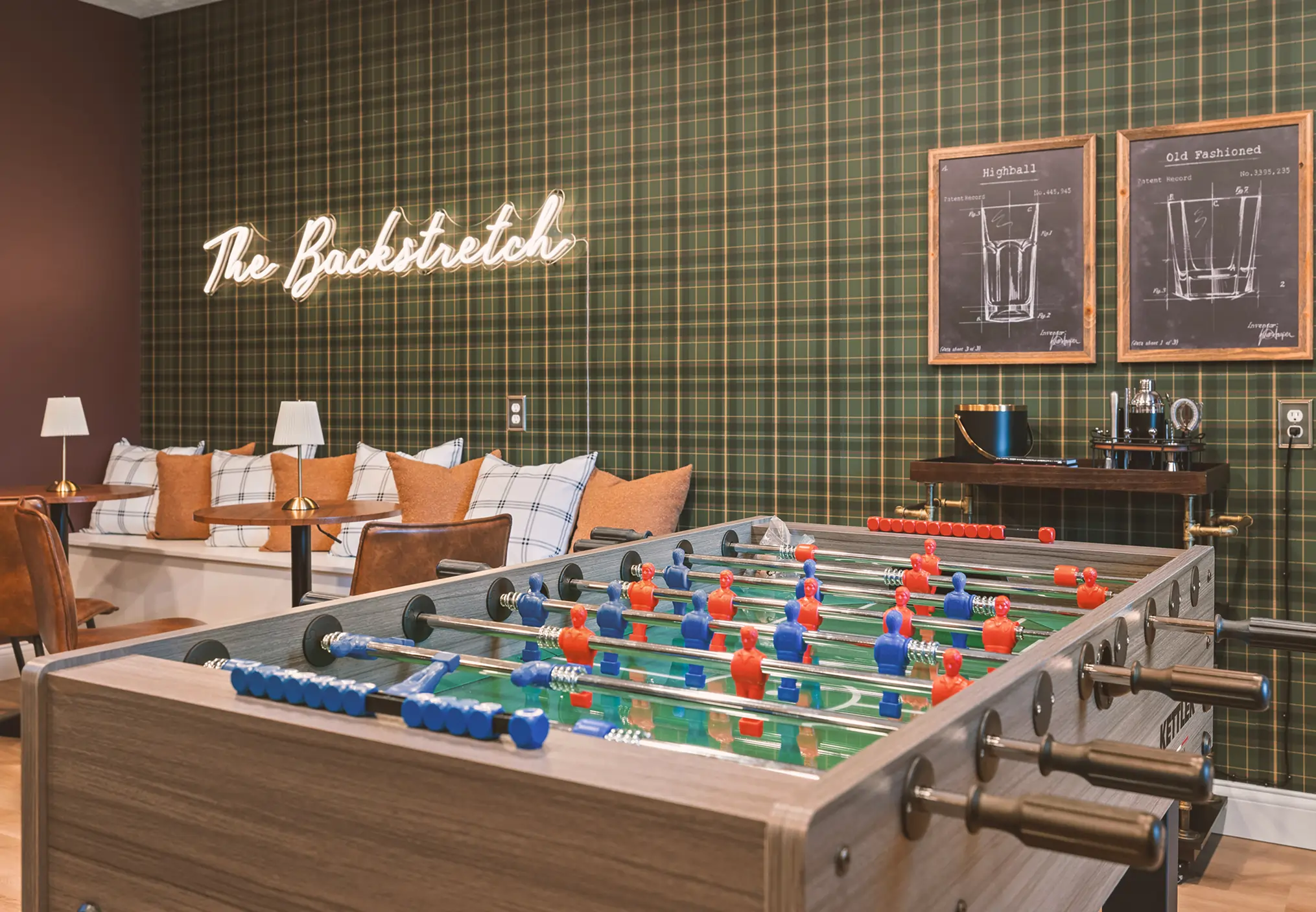Game room in rental property, Roxie House. Foosball game being displayed with modern plaid wallpaper.