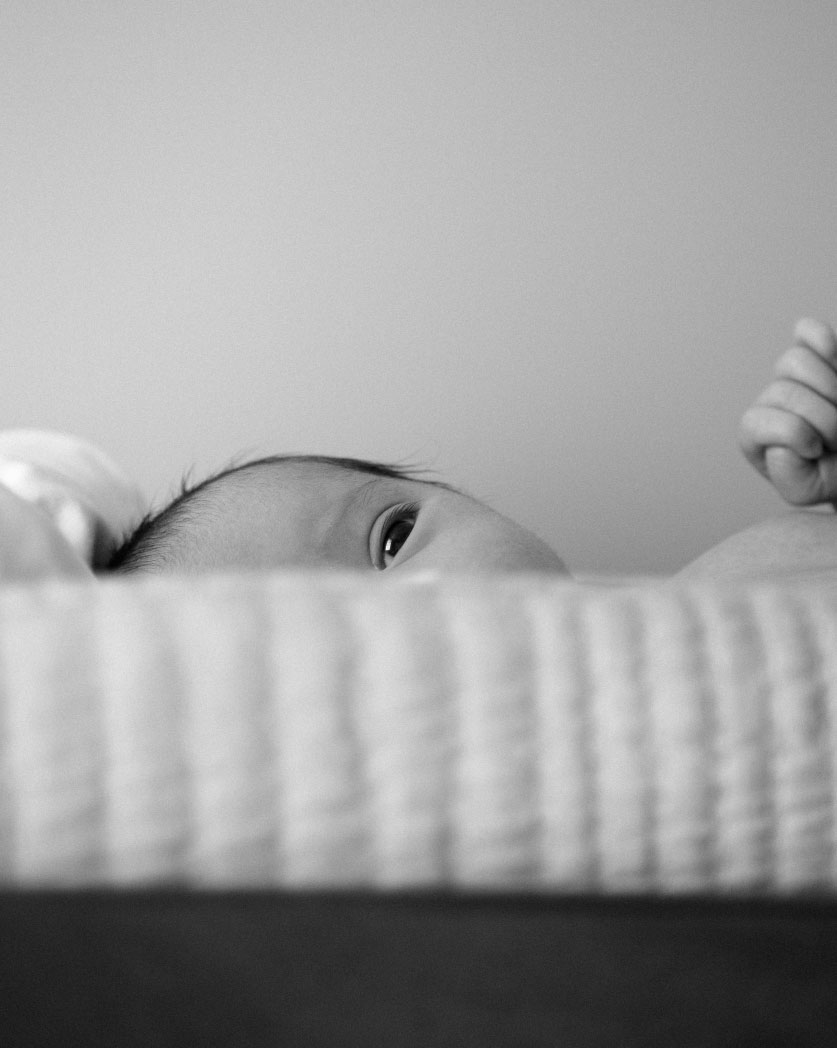 The Baby Consultancy - Maternity Nurse services- Baby peeping over cot