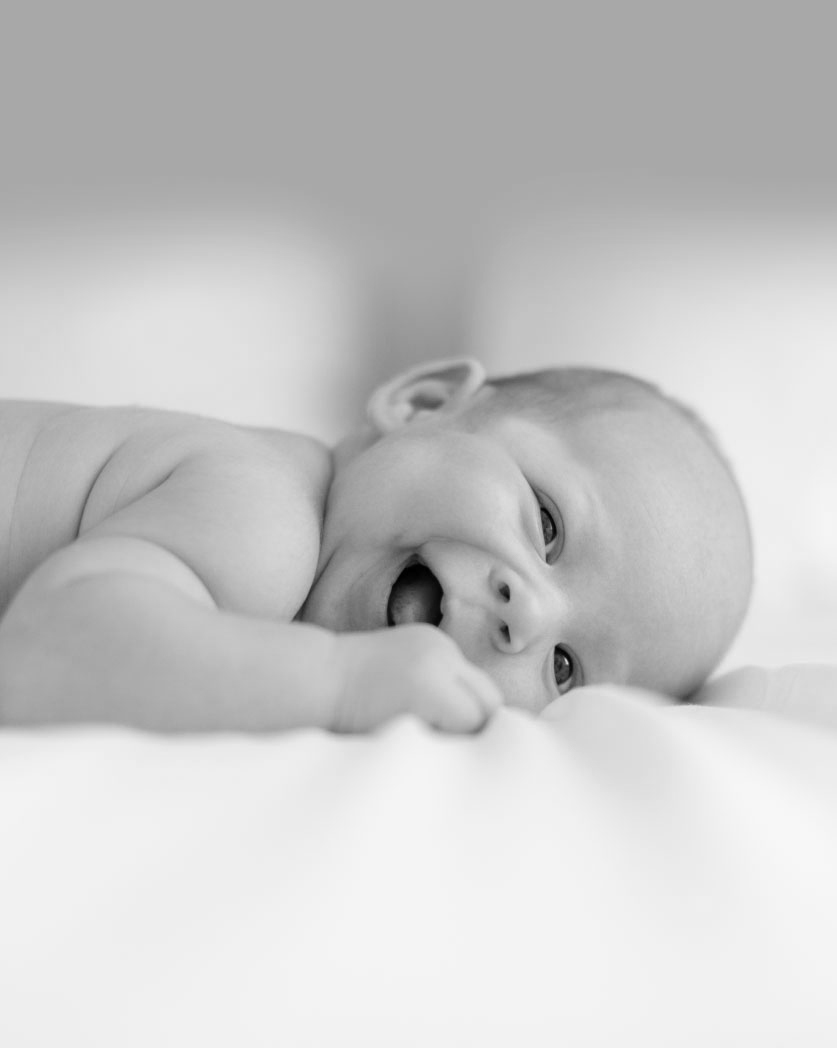 The Baby Consultancy - Maternity Nurse Services - Baby enjoying tummy time and smiling