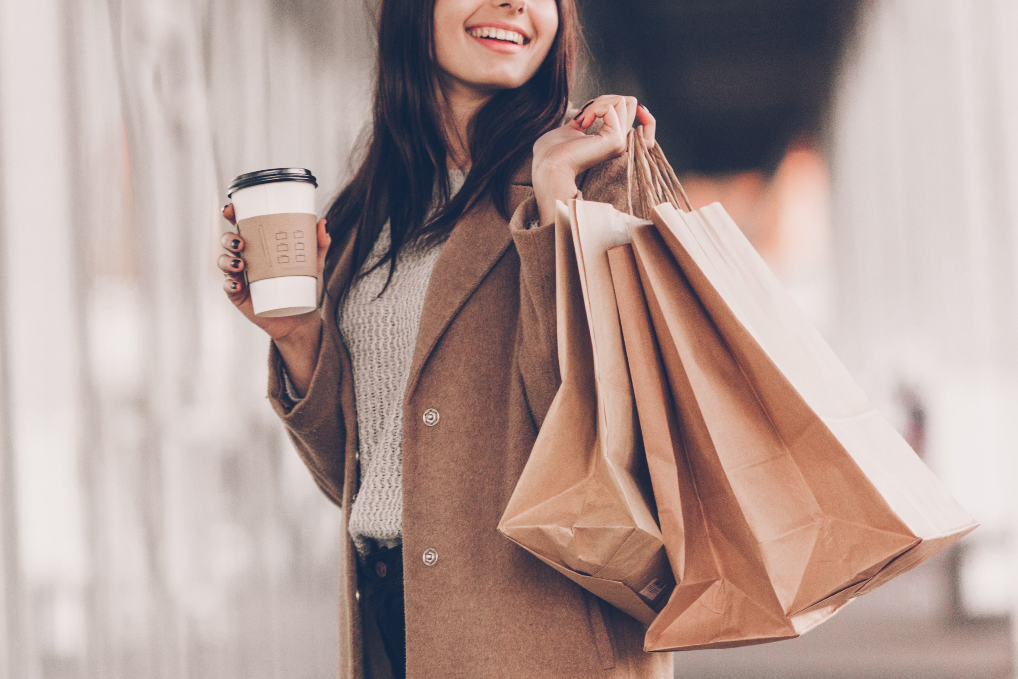 woman holding coffee and shopping bag stock image