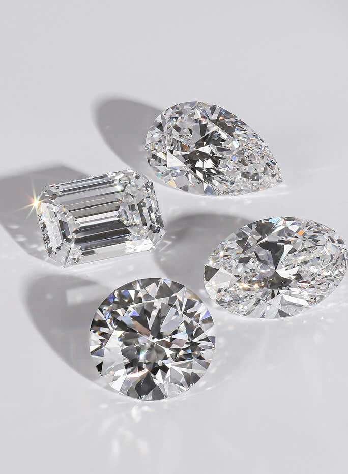 4 lab diamonds: pear shape, emerald cut, oval cut, and round brilliant.