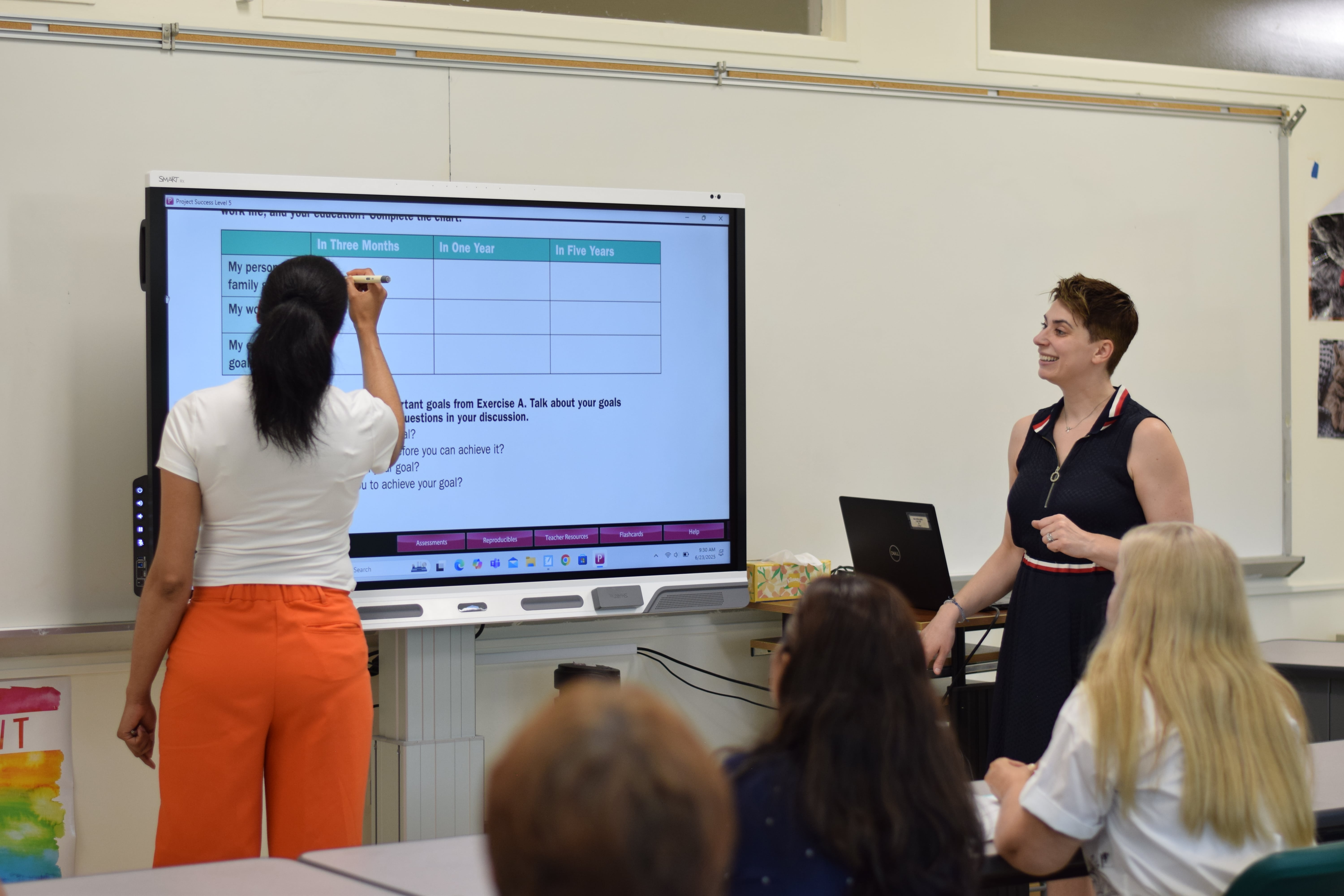 The student is writing English sentences on the board. 