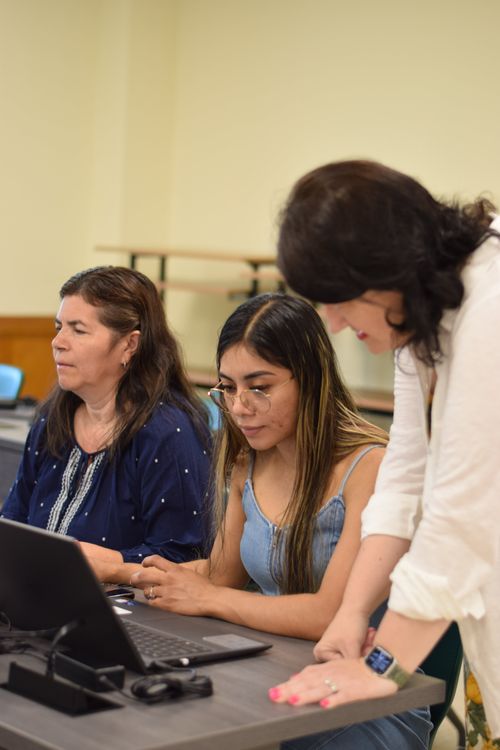 The student and the teacher are working together at the computer.