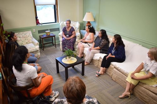 The support meeting is taking place in the library, students are present, and Yolanda Ortiz is speaking.