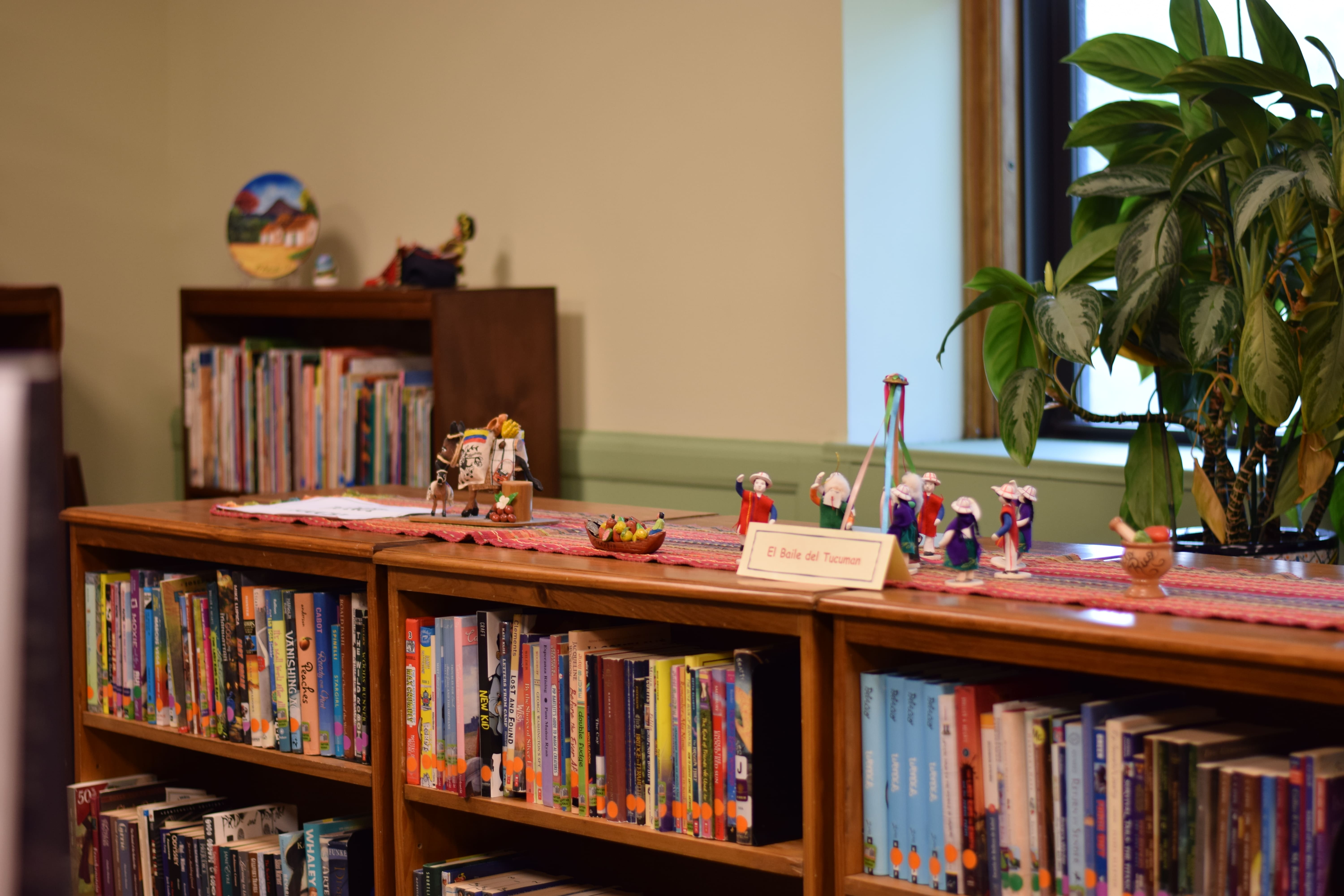 Small figures are standing on the bookshelves. 